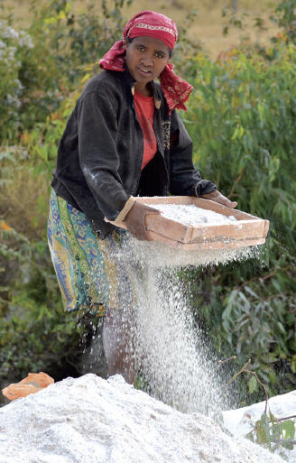 Woman sifting kaoline, product of weathering feldspar and mica, looking for gem fragments of tourmalines. J. Gajowniczek photo.